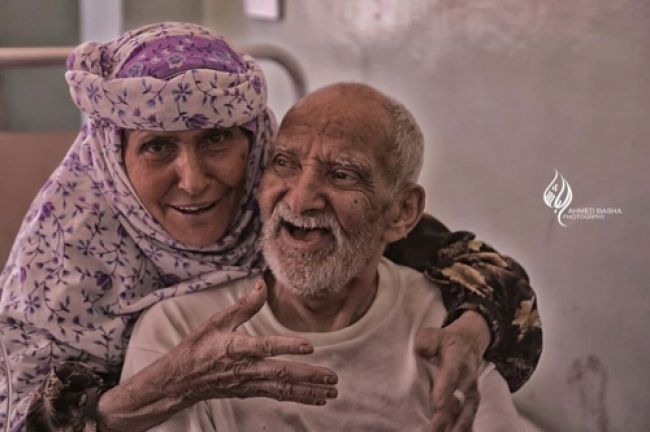 أنباء عدن | صورة لـ"مسن يمني" مصاب بالكوليرا، وزوجته تحتضنه بضحكة مدوية.. تشعل مواقع التواصل الاجتماعي (صور)